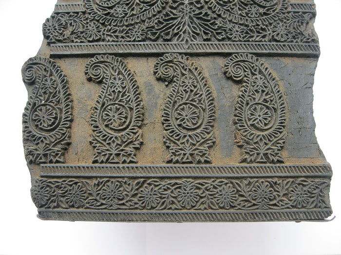 A carved wooden block with fine outline work
