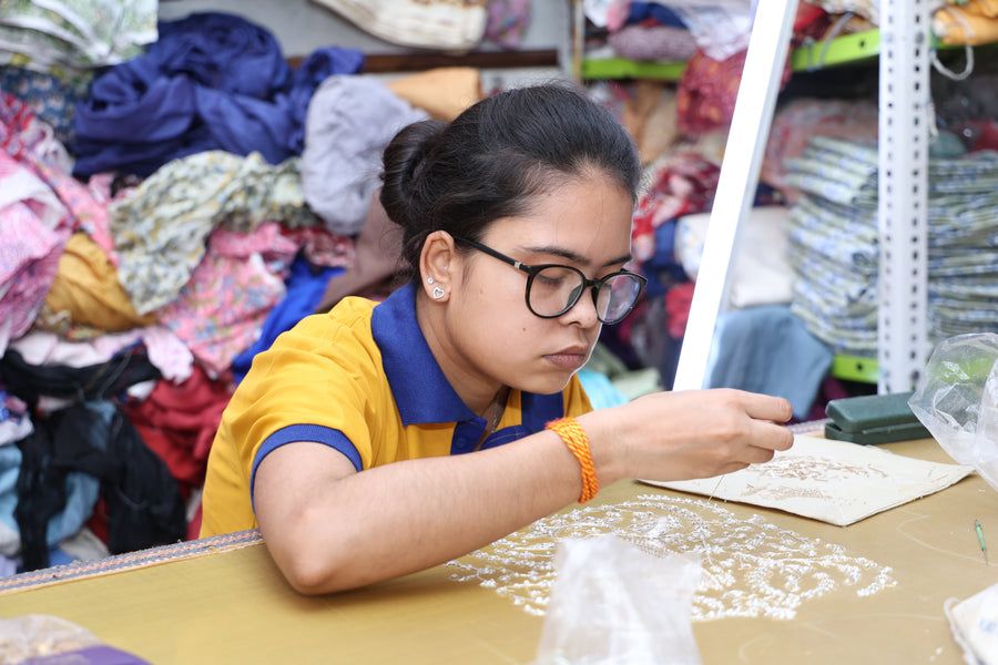A young woman learning fine embroidery with Jaipuri Banno
